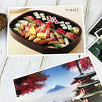 Assorted sushi in a wooden box with Mount Fuji and cherry blossoms in the background