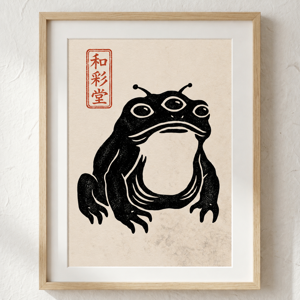 Framed artwork of a black frog illustration on a beige background with red text.