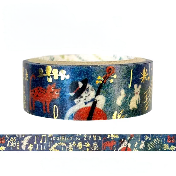 A roll of decorative washi tape with a dark blue background featuring whimsical illustrations of a black cat playing a cello, a red cat, white rabbits, musical notes, and gold symbols, shown with a strip unrolled below on a white background.