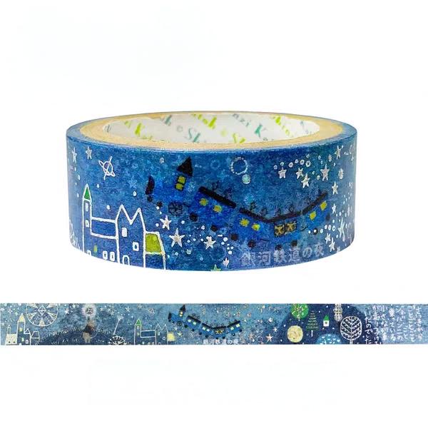 A roll of decorative washi tape with a blue winter night scene pattern, featuring white stars, houses, a train, and small illustrated elements. A strip of the tape is shown below the roll on a plain white background.