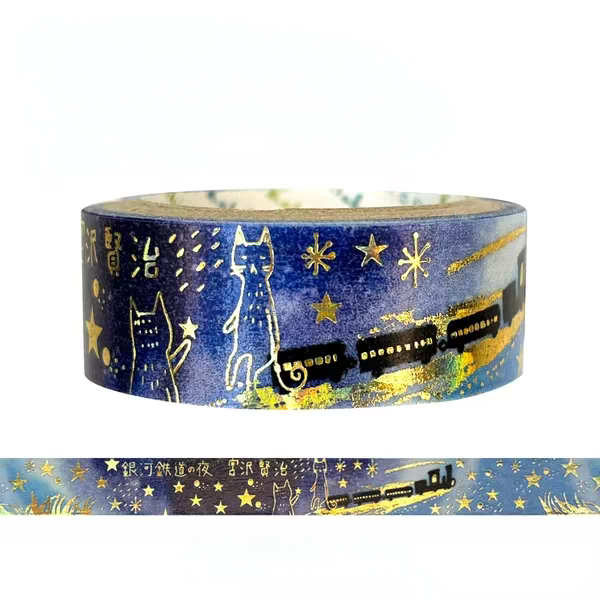A roll of decorative washi tape featuring a blue night-sky design with gold stars, two white cat silhouettes, and a black train illustration, shown on a white background with a flat strip preview below.