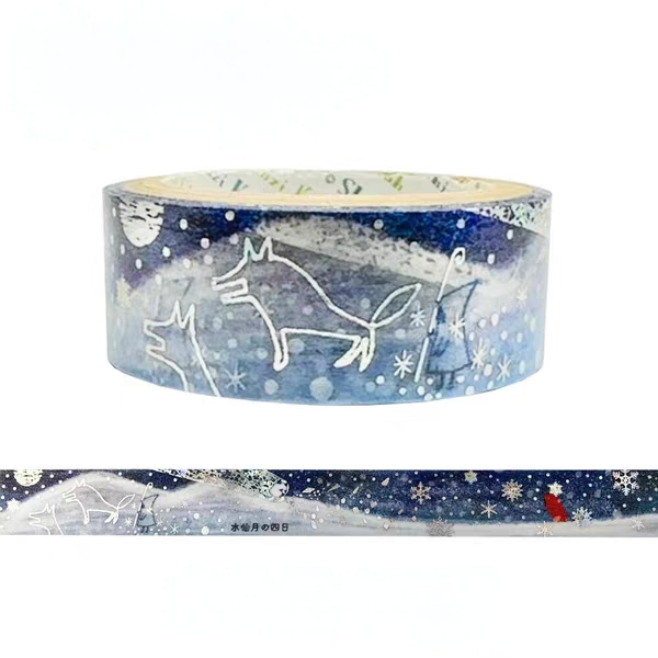 A roll of decorative washi tape with a winter landscape design, featuring white line drawings of dogs and sleds over a blue snowy background, with a horizontal strip showing the full pattern.