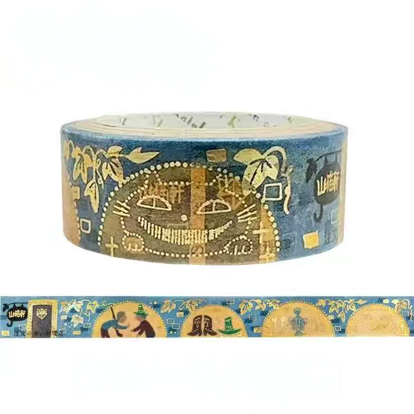 A roll of decorative washi tape with a blue background and gold-toned illustrated patterns, shown with a strip unrolled below on a white background.