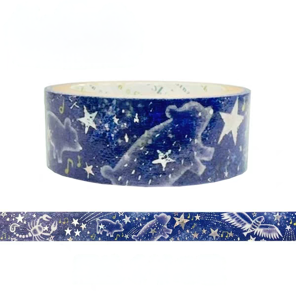 A roll of decorative washi tape with a deep blue space theme, featuring silhouettes of a bear, stars, and musical notes, with a strip of the tape shown horizontally below on a white background.
