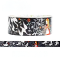 A roll of decorative washi tape with a black background and a whimsical white, red, and orange illustrated pattern, shown with a horizontal strip preview below on a white background.