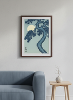 Framed artwork of a tree and moon on a wall above a sofa.