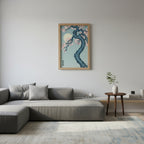 Living room with a gray sectional sofa, decorative pillow, and a framed artwork of a cherry blossom tree on the wall.